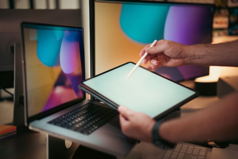 Designer using a digital pen on a tablet with colorful screens in a modern home office setting. — 4 Uses Of Cheap Cpanel Host