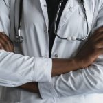 Close-up of a confident doctor in a lab coat standing with crossed arms and stethoscope. — 5 Reasons to Choose Laparoscopic H