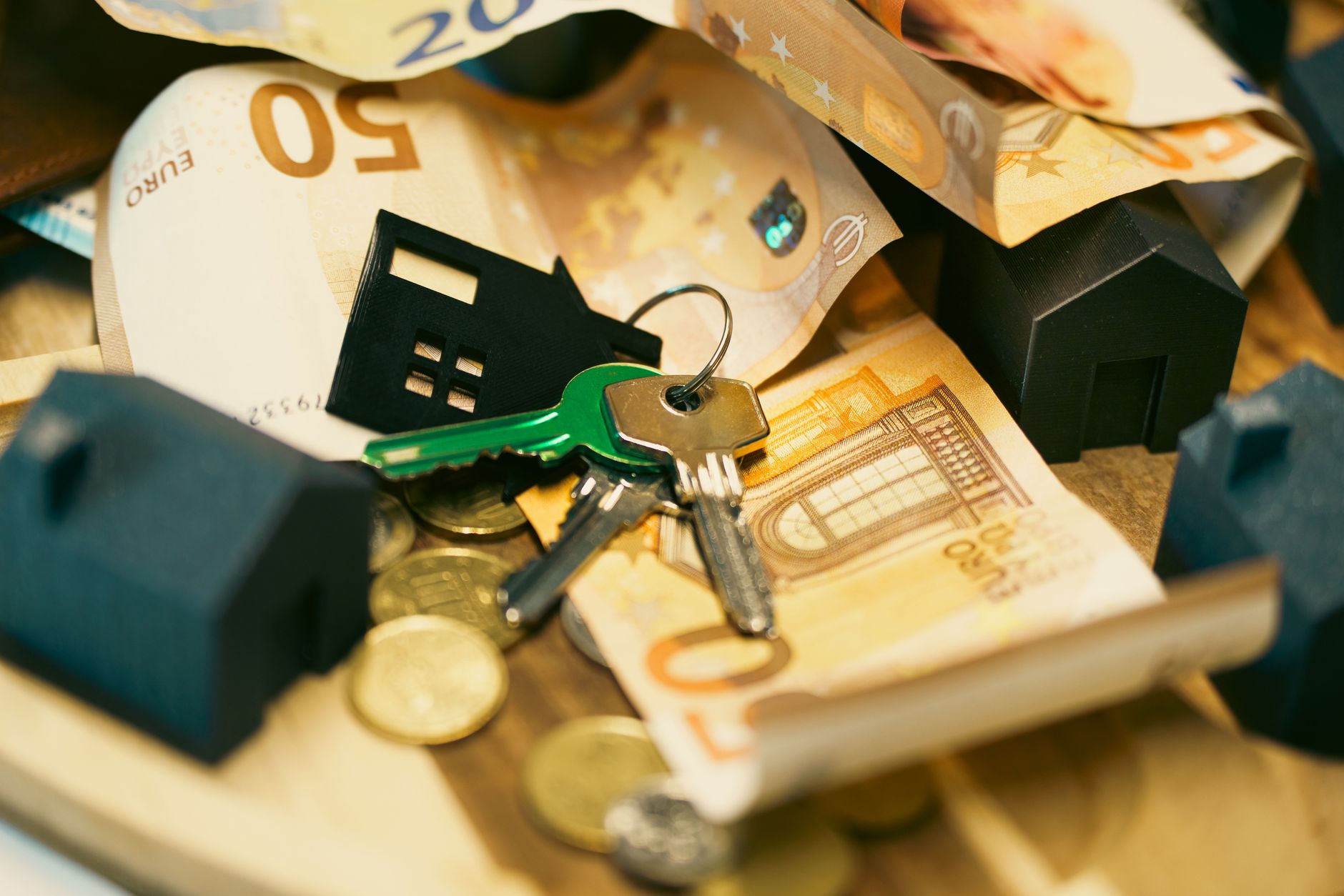 Euro currency with house keys and miniature models, symbolizing real estate investment. — 5 reasons to use a loan app to appl