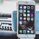 Close-up of a smartphone mounted on a car dashboard showing home screen with apps. — 5 Things to Consider Before Investing in
