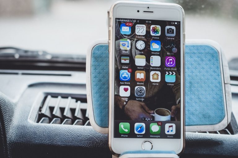 Close-up of a smartphone mounted on a car dashboard showing home screen with apps. — 5 Things to Consider Before Investing in