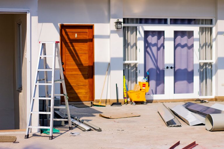Front entrance of a house under renovation with tools and materials scattered around. — 5 things to consider when buying curt