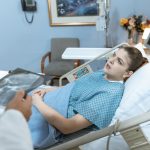 Caucasian woman in hospital bed receiving care from healthcare professional. — A Perfect Fit for My Machine