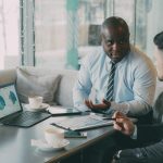 Two business professionals engaged in discussion over laptops and documents. — Always approach the budget friendly space thro