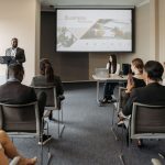 A diverse group of adults attending a presentation in a conference room setting. — An Introduction to Using a Ledger Nano X a