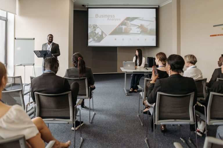 A diverse group of adults attending a presentation in a conference room setting. — An Introduction to Using a Ledger Nano X a