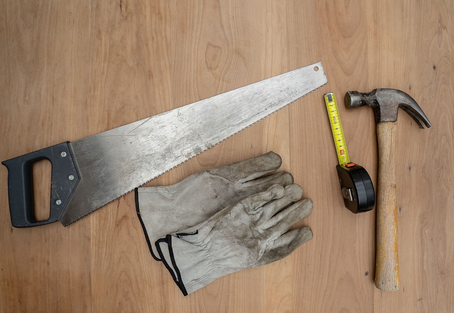 Flat lay of essential carpentry tools including a saw, hammer, and tape measure on wooden surface. — Are the shaggy rugs a be