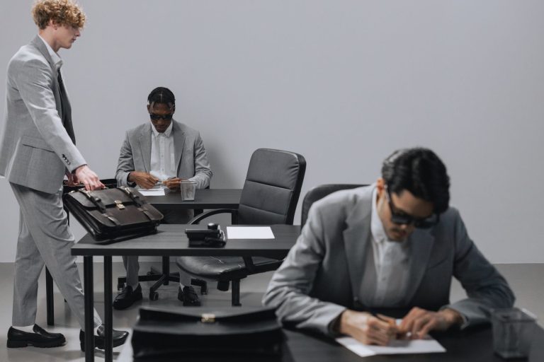Business office with diverse employees in gray suits working at desks in an indoor setting. — Asbestos Surveys Explained: A S