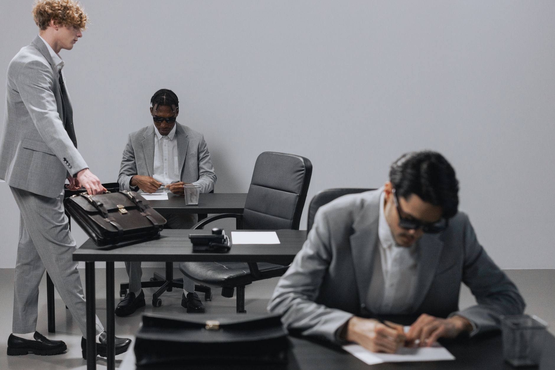 Business office with diverse employees in gray suits working at desks in an indoor setting. — Asbestos Surveys Explained: A S