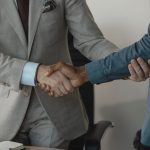 Image of a professional handshake between two businessmen in an office setting. — Benefits of Using the Best Eyelash Conditio