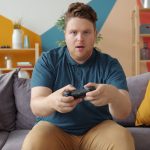 A young man intensely playing video games in a modern living room setting. — Best Online Casino Games for New Players: A Begi