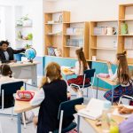 Teacher engaging students with a globe in a diverse classroom setting for interactive learning. — Bhubaneswar And The New Age