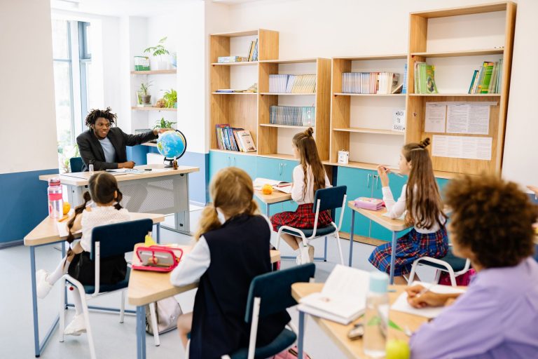Teacher engaging students with a globe in a diverse classroom setting for interactive learning. — Bhubaneswar And The New Age