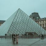 A winter day at the iconic Louvre Museum pyramid in Paris, capturing tourists and the architectural beauty. — Comprehensive G
