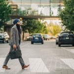 Sikh businessman with a turban crossing a city street on a zebra crossing, carrying a briefcase. — Cool Down Your Summer Heat