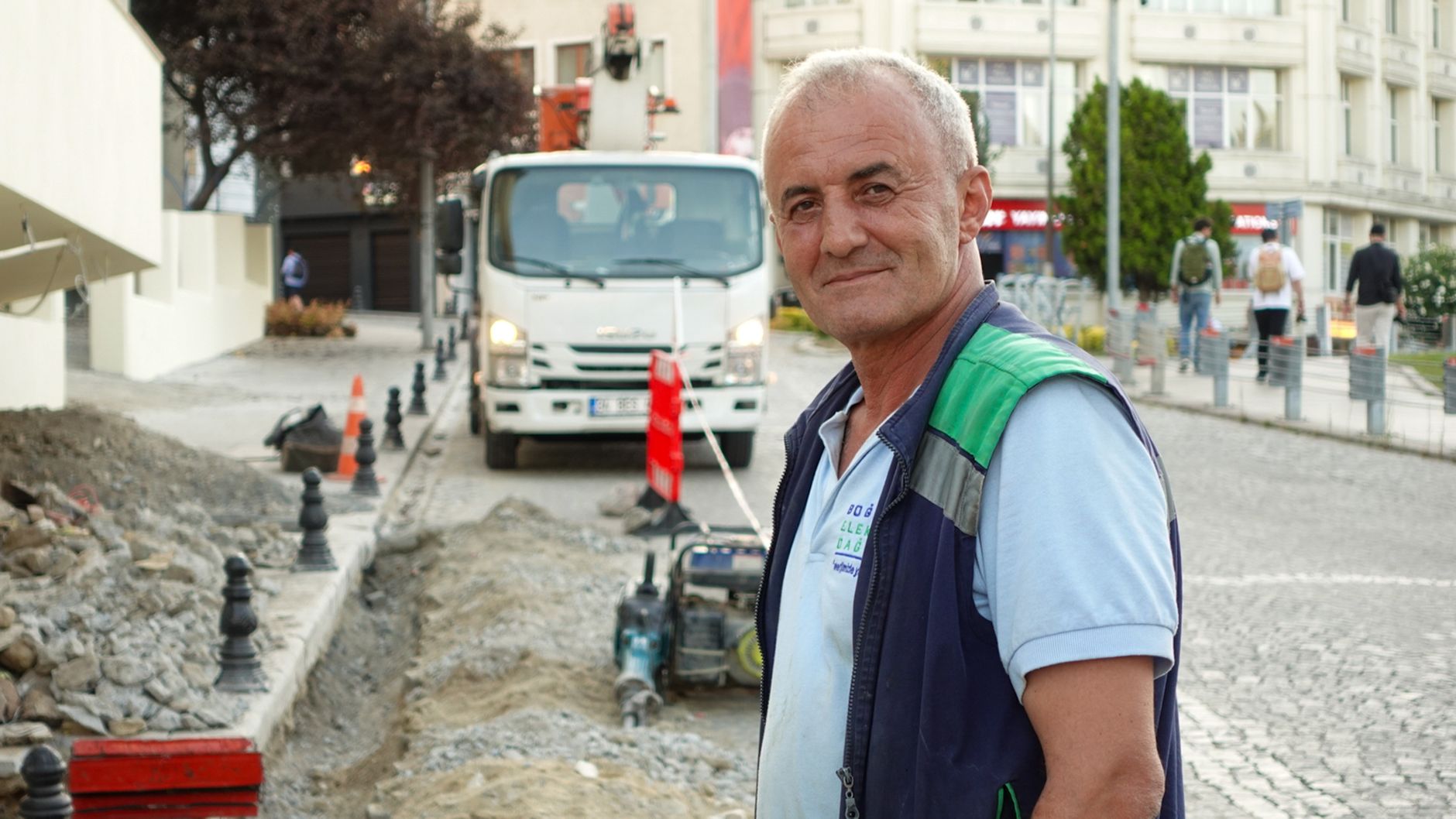 Smiling construction worker on a city street with vehicles and buildings. — Enjoy the bonus offers on the verification site?