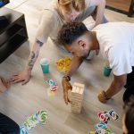 Group of friends enjoying board and card games in a cozy home setting. — Esports Continue to Trend Across the Board