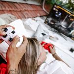 A couple playing video games outdoors, focusing on the controllers and screen. — Exploring the Different Types of Online Casi