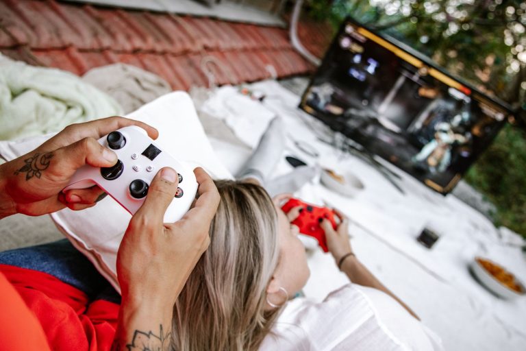 A couple playing video games outdoors, focusing on the controllers and screen. — Exploring the Different Types of Online Casi