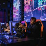 Two gamers intensely focused in a professional eSports competition with vibrant game visuals. — Football betting guide for be