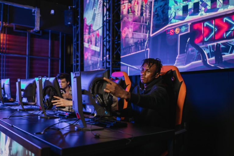 Two gamers intensely focused in a professional eSports competition with vibrant game visuals. — Football betting guide for be