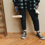 A person holding a paint roller and brush during a home renovation project. — Four Tips For Maintaining Solar Panels