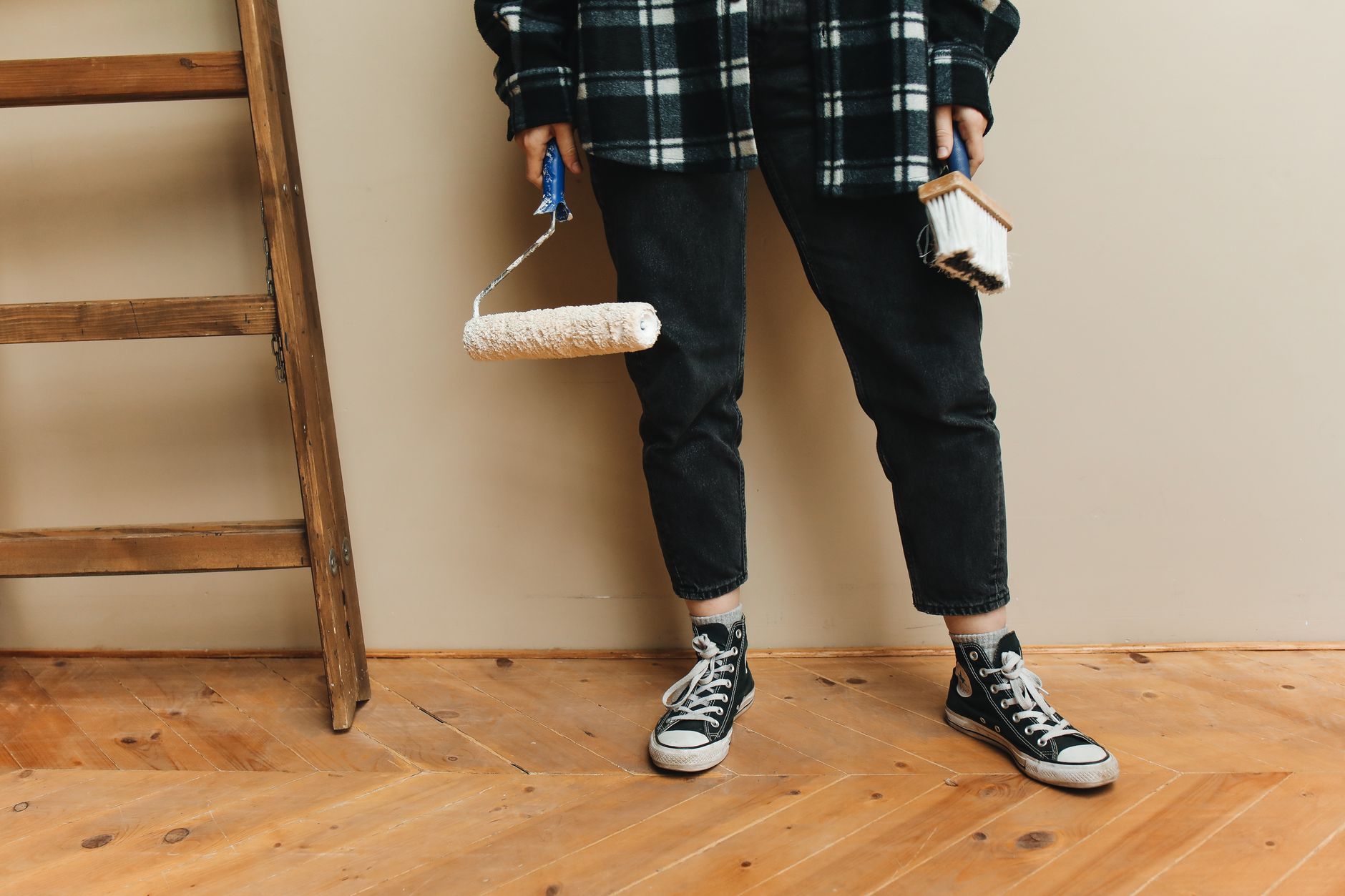 A person holding a paint roller and brush during a home renovation project. — Four Tips For Maintaining Solar Panels