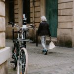 A city street with a bicycle and person walking down a cobblestone path. — Gifting Coffee Mugs from Namshi throughout the Yea
