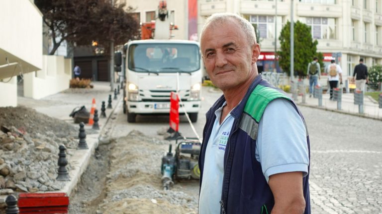 Smiling construction worker on a city street with vehicles and buildings. — Guide on How to Use Postal Validation services