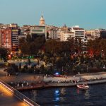 Scenic view of Istanbul's skyline featuring Galata Tower and bustling park at twilight along the waterfront. — How To Find Th