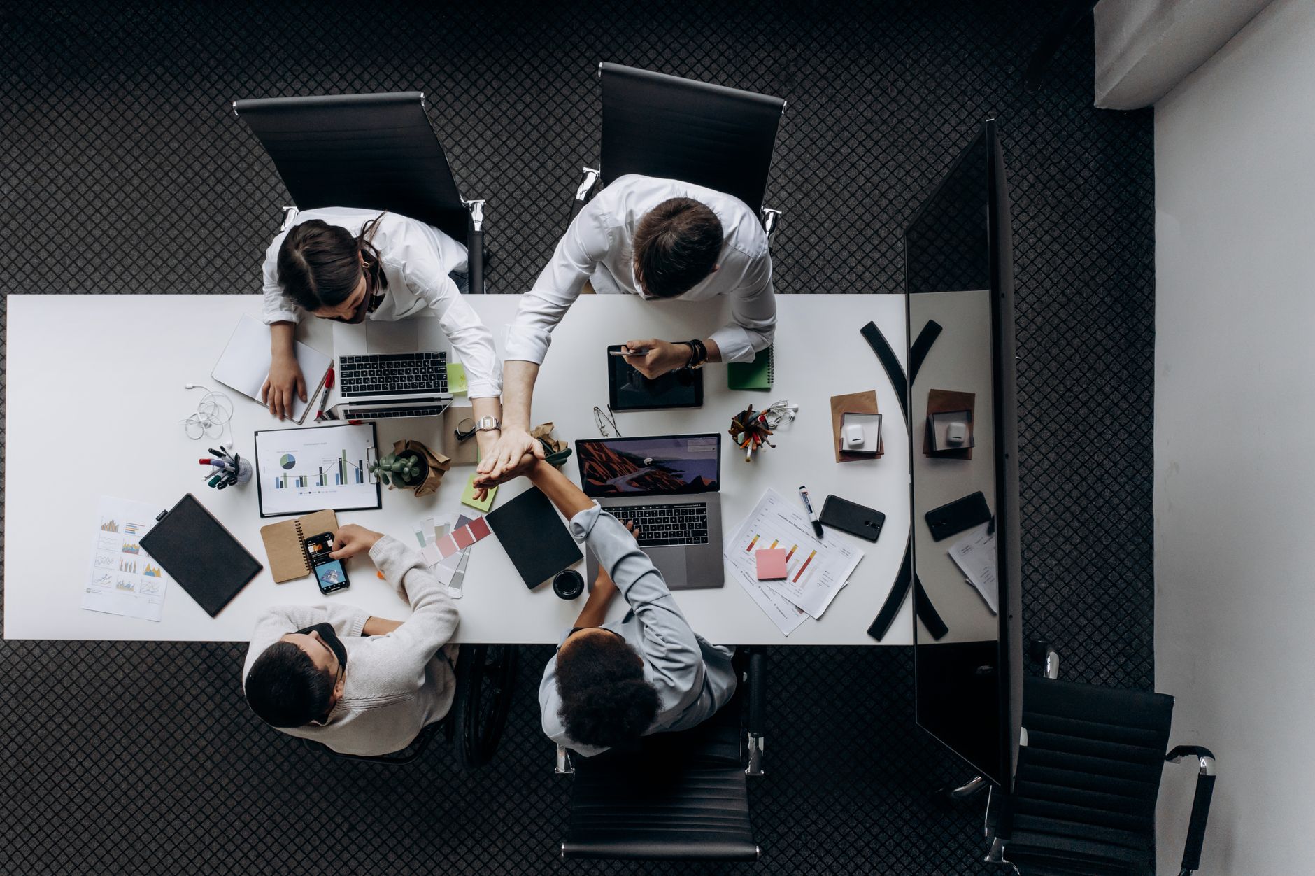 High angle view of colleagues collaborating around a conference table in a modern office setting. — How To Leave A Good Impre