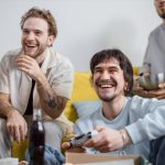 Group of friends laughing and enjoying video games together indoors. — How to Make an Escape Room For Kids