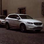 White Volvo SUV parked on cobblestone city street during winter with Christmas decorations. — How to Select a New Garage Door