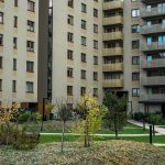 Contemporary high-rise apartment buildings with lush greenery and pathways in the courtyard. — How to Sell your Washington Pr
