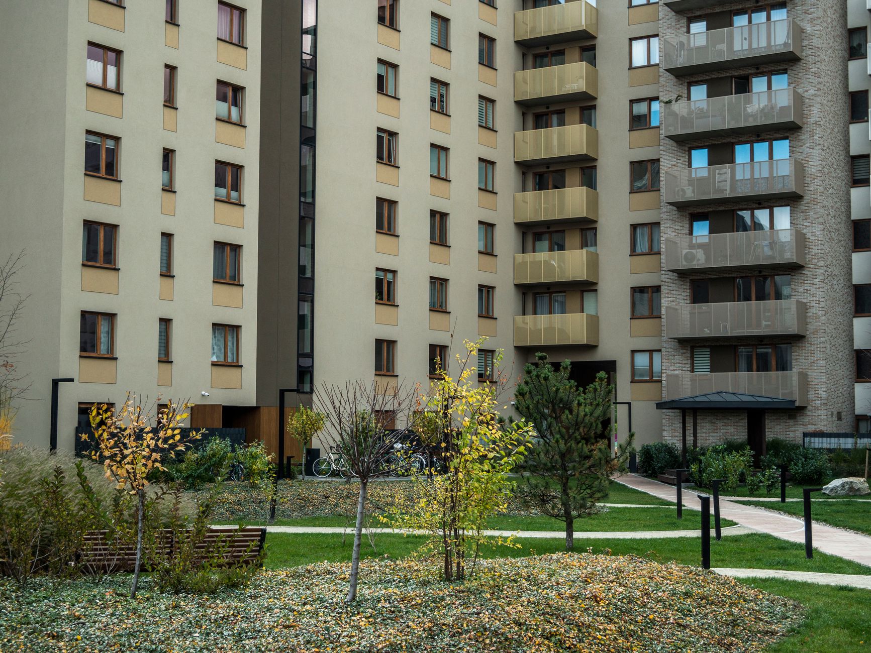 Contemporary high-rise apartment buildings with lush greenery and pathways in the courtyard. — How to Sell your Washington Pr