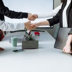 Professionals sealing a deal with a handshake across a conference table during a business meeting. — Important Tips to Consid