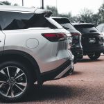 A row of parked SUVs including a silver Infiniti QX60 in an outdoor setting. — Inspection Checklist for Buying a Used Motorcy