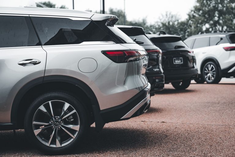 A row of parked SUVs including a silver Infiniti QX60 in an outdoor setting. — Inspection Checklist for Buying a Used Motorcy