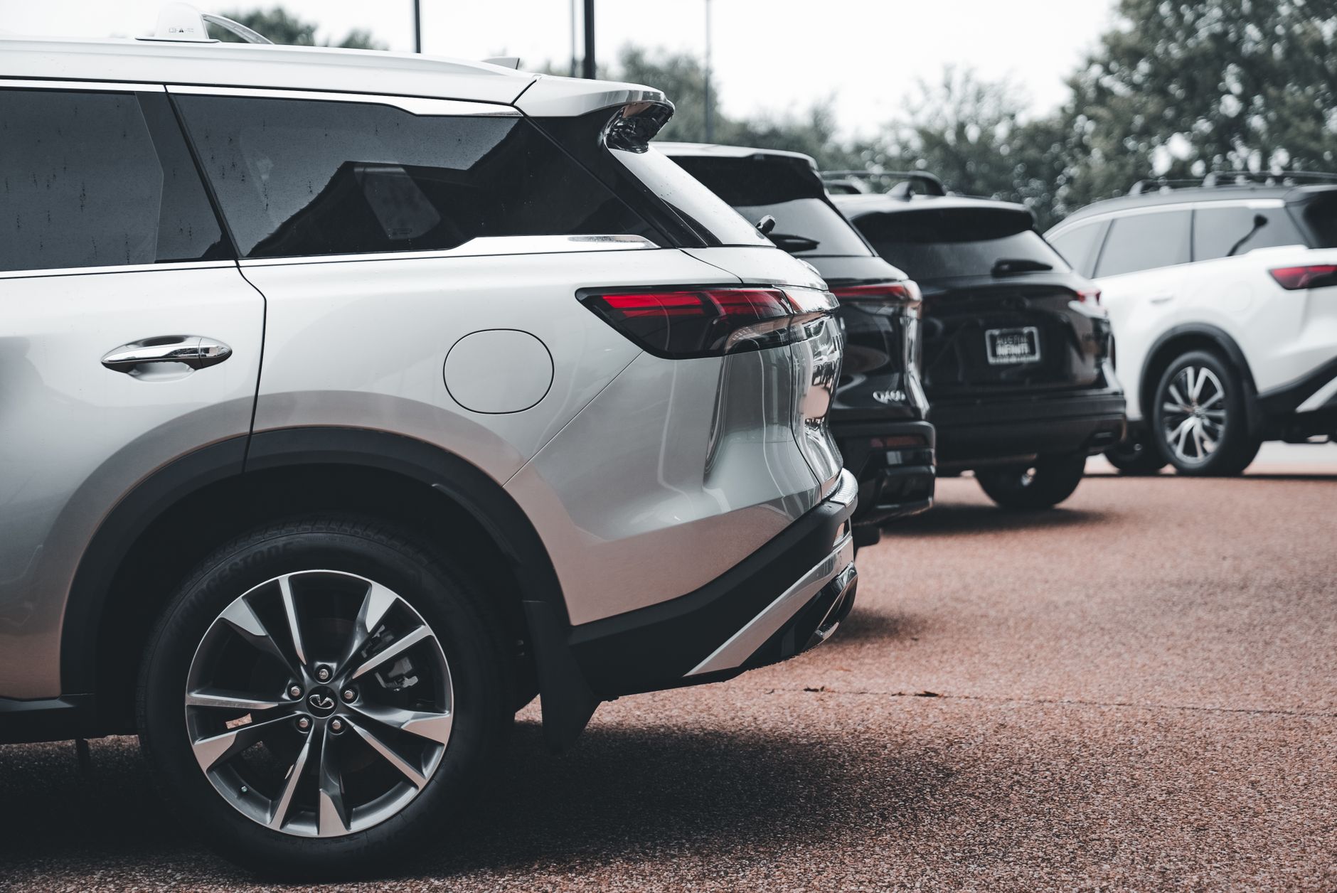 A row of parked SUVs including a silver Infiniti QX60 in an outdoor setting. — Inspection Checklist for Buying a Used Motorcy