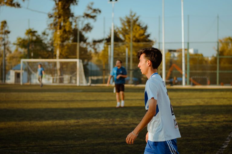A teenager plays soccer outdoors on a sunny day, enjoying friendly competition. — IPL Fantasy Betting Tips: Five Batsmen duri