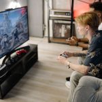 Two friends immersed in playing video games together in a cozy living room. — Know the art and craft of playing Satta Matka
