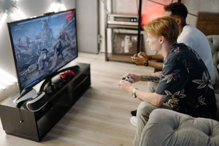 Two friends immersed in playing video games together in a cozy living room. — Know the art and craft of playing Satta Matka
