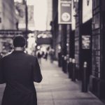 Man in a suit walking down a city street in a lonely, urban setting. — Legal Neuroscience and Imaging Research by Dr. Andrew