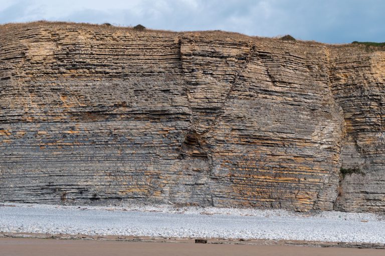 Detailed view of sedimentary rock layers along a coastal cliff face. — Make Sure You Follow All Deadline Requirements for You