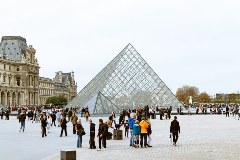 Tourists gather around the iconic Louvre Pyramid in Paris, highlighting European architecture. — Making the Right Choices for