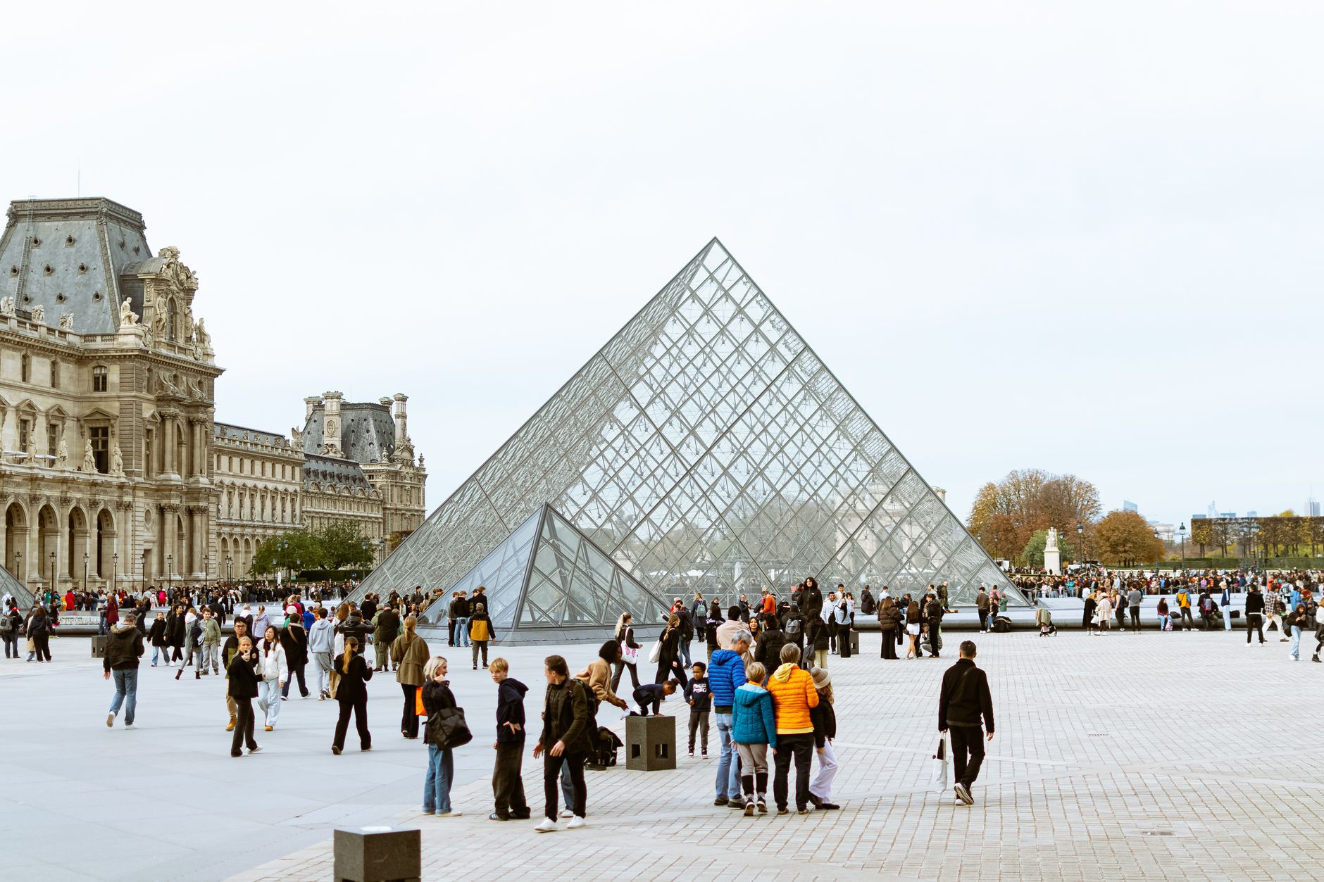 Tourists gather around the iconic Louvre Pyramid in Paris, highlighting European architecture. — Making the Right Choices for
