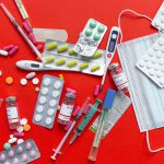 Medical supplies and medications displayed on a red background, emphasizing healthcare essentials. — Navigating Migraine Reli