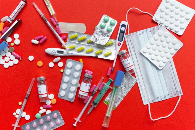 Medical supplies and medications displayed on a red background, emphasizing healthcare essentials. — Navigating Migraine Reli