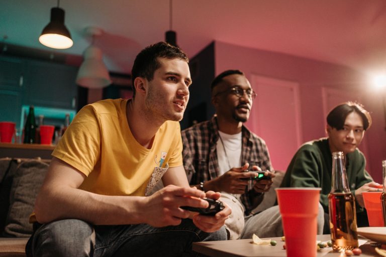 Diverse group of young adults playing video games on a cozy sofa with refreshments. — Play with Confidence at Macau Online Ca