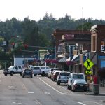 Lively urban street with cars, shops, and pedestrians during daytime. — Preserving Memories Forever: The Magic of an Audio Gu